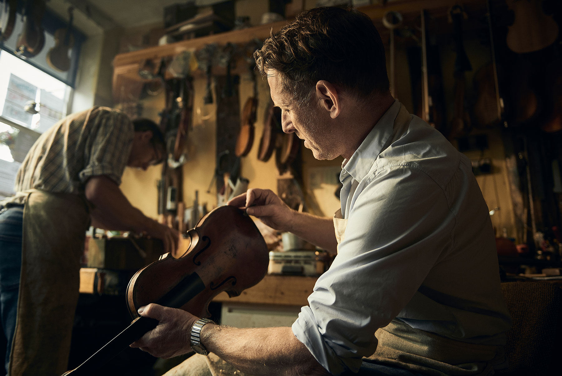 Portrait of a luthier in a violin repair shop